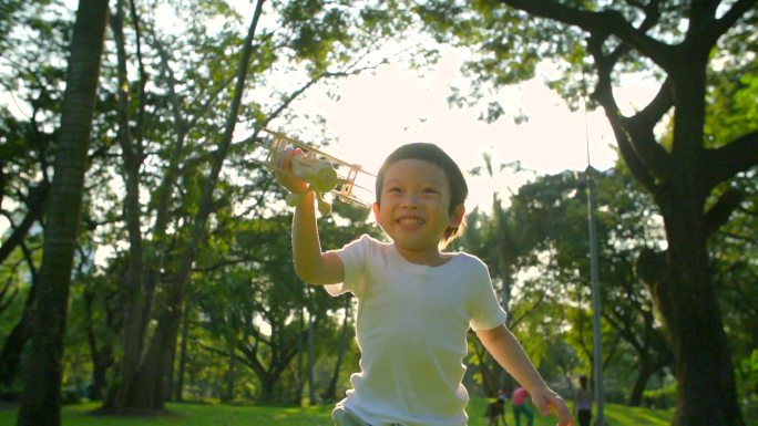 快乐的孩子在公园玩木飞机