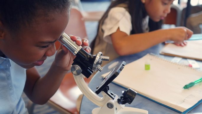 可爱的学生用显微镜检查东西