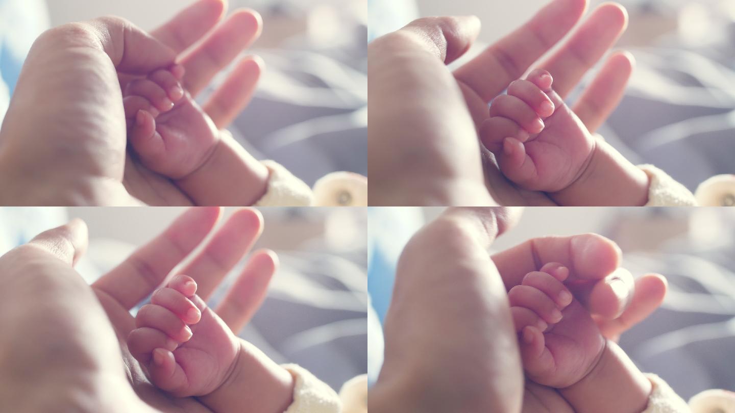 牵着新生婴儿的手呵护珍爱幼嫩