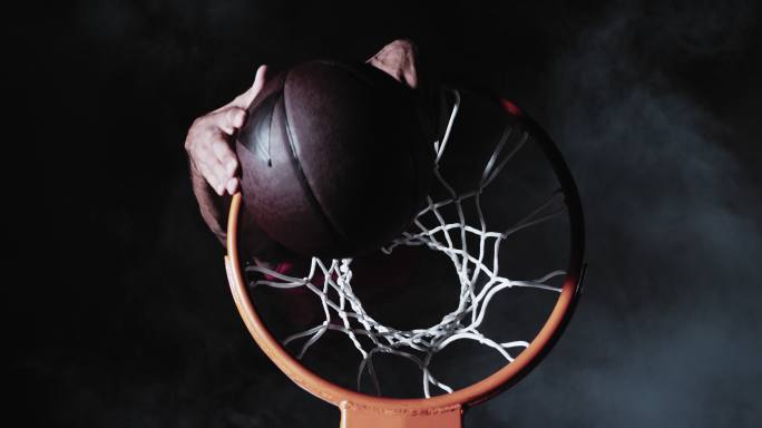 一个穿红衣服的篮球运动员表演扣篮