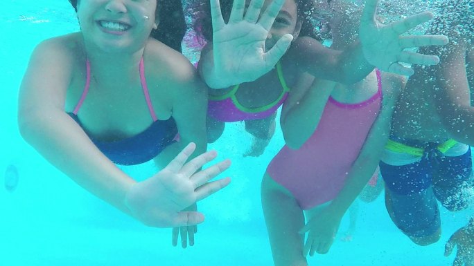 四个孩子在水下向镜头游去