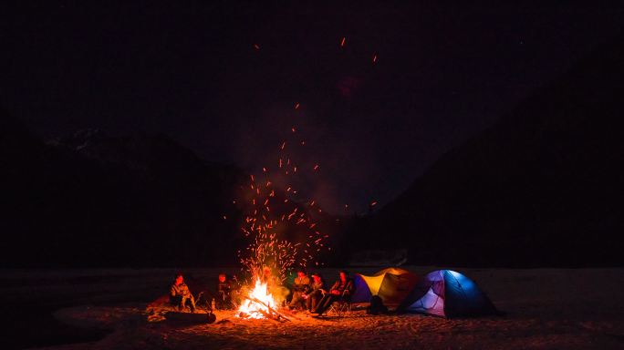 一群朋友坐在营火旁