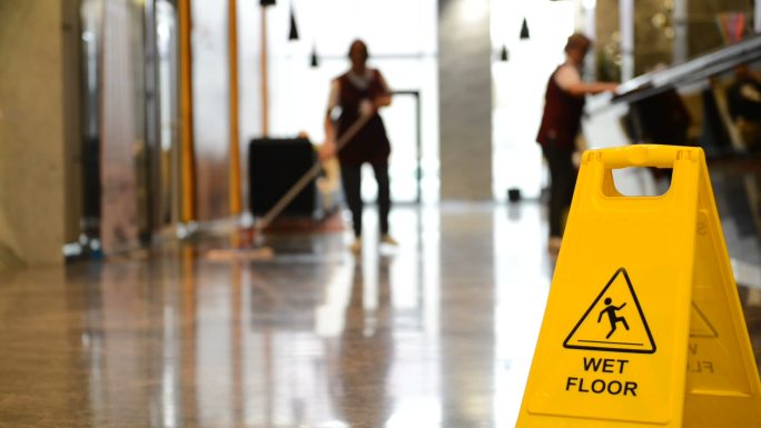 工人清洁大厅地板，警告标志。