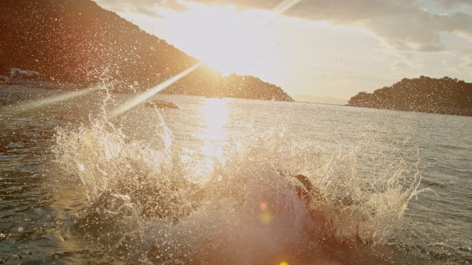 超级慢镜头母女在日落时跳入大海
