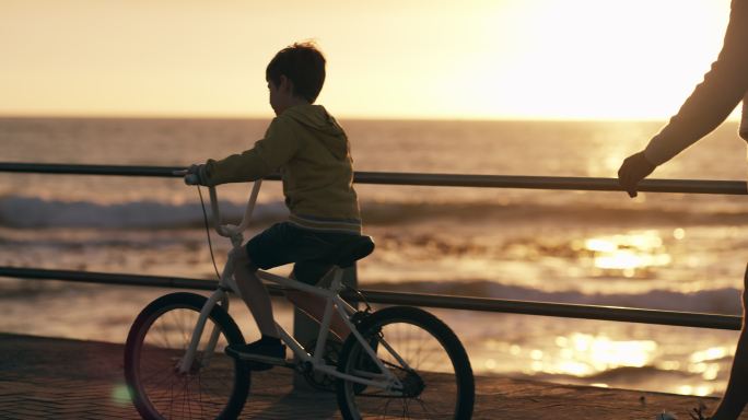 一个父亲教孩子骑自行车