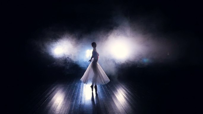 一位芭蕾舞演员在一间薄雾弥漫的房间里表演