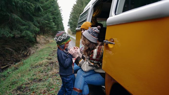 两个女人和小男孩坐在复古露营车里