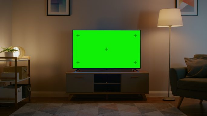在客厅里，有一台绿色屏幕的电视机