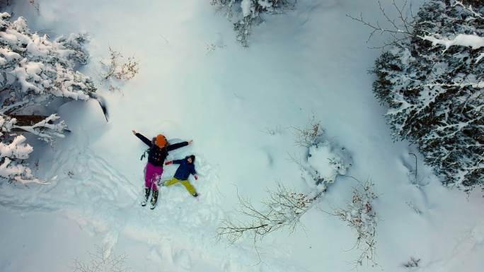 在雪地玩耍雪景躺在雪地上玩耍妈妈带小孩