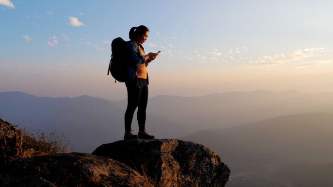 登山者在山顶上使用手机