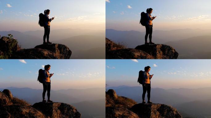 登山者在山顶上使用手机
