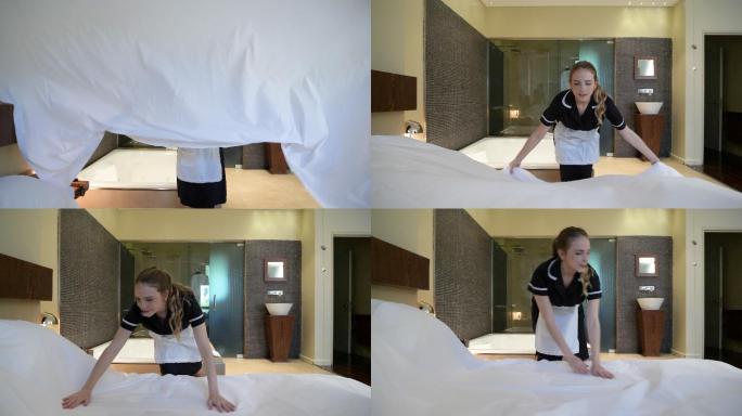 管家在酒店铺床把床单铺在床上