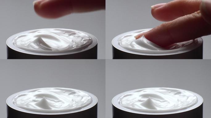 手触摸乳霜保湿产品的特写镜头。