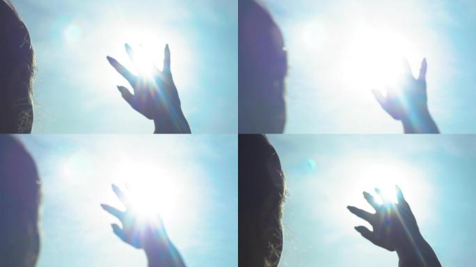 女孩用手遮住太阳触摸阳光温暖指尖指缝阳光