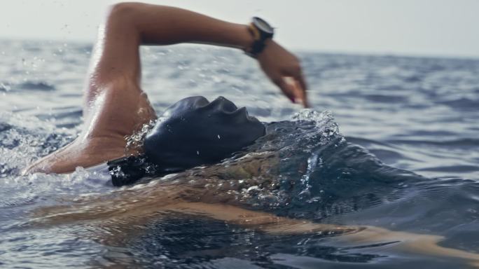一名女游泳运动员在海洋中向前爬行的动作