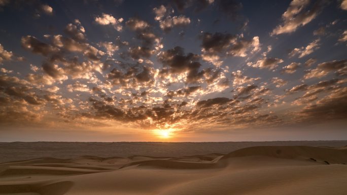 日出和云在沙漠景观上移动的时间点