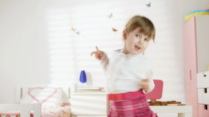有趣的小女孩在她的房间里跳舞