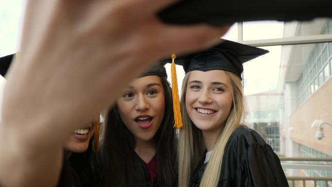 高中或大学女生朋友在毕业典礼后自拍。