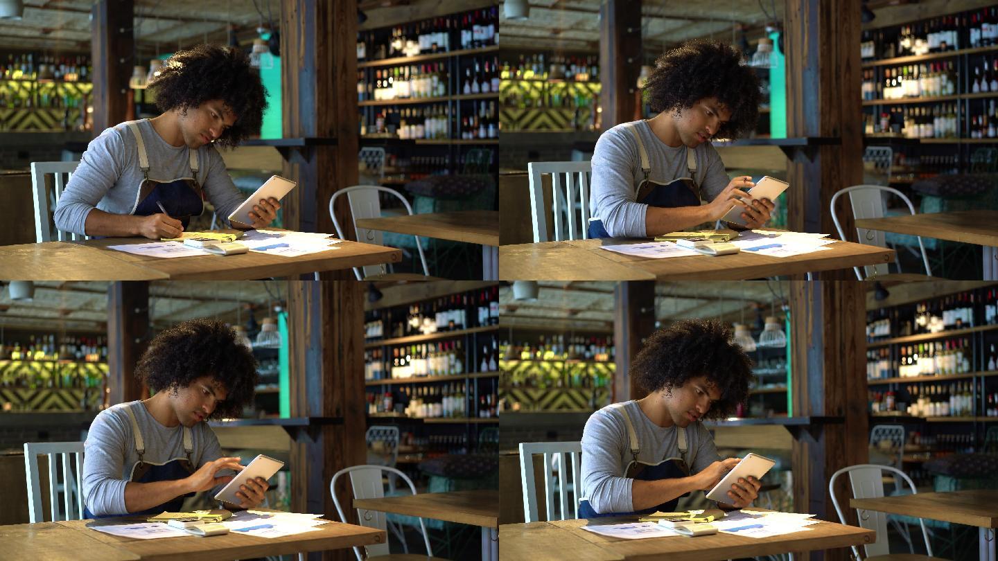餐馆老板用平板电脑在记事本上做笔记
