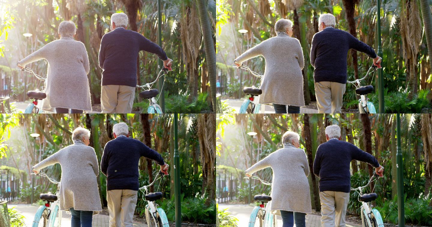 一对年迈的夫妇推着自行车向前走去
