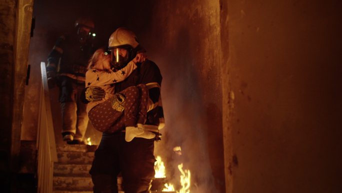 一个消防员把获救的女孩抱在怀里
