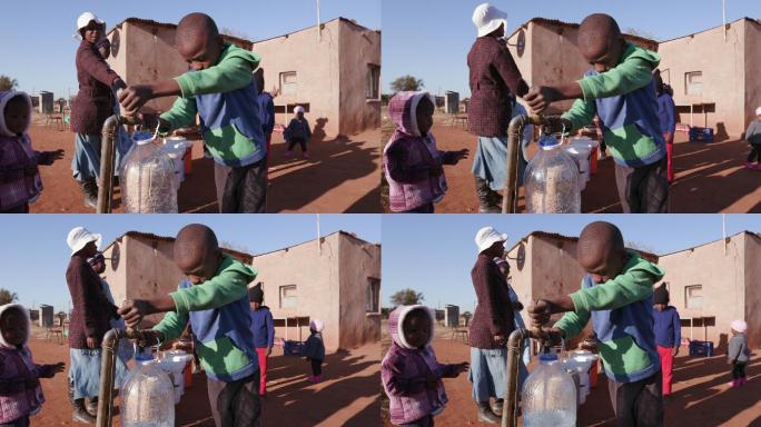 一名非洲男孩在水龙头取水