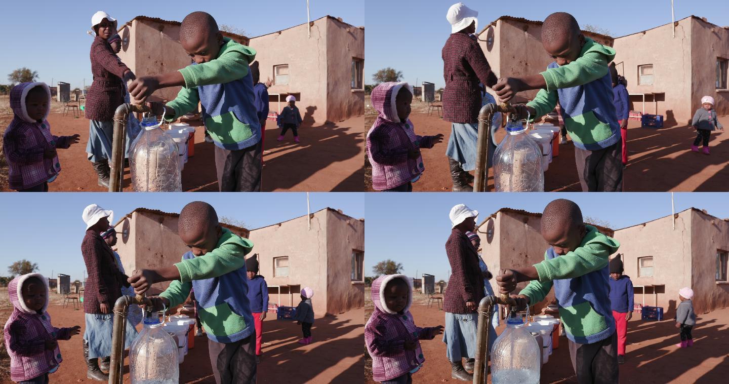 一名非洲男孩在水龙头取水