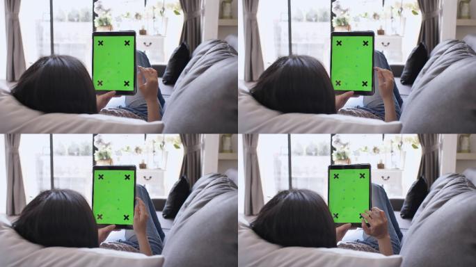 女人躺在沙发上玩平板电脑