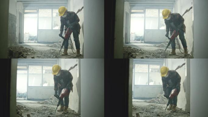 一个工人正在凿掉房子里的水泥地板