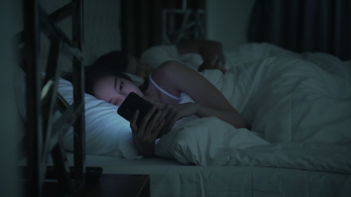在床上玩手机的女人