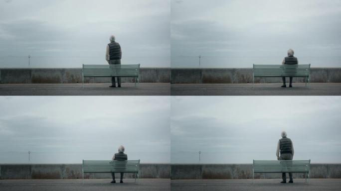 老人坐在海边孤独的老人坐在长椅上迷茫彷徨