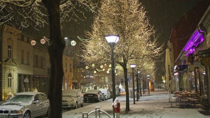 雪花飘落在大街上的圣诞灯上