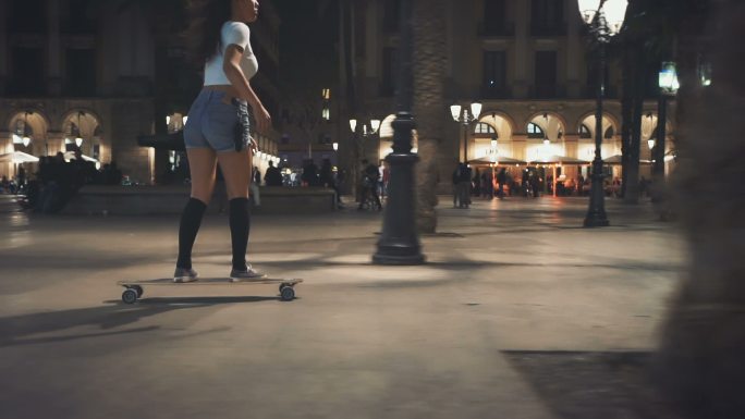 晚上在街上玩滑板的女人