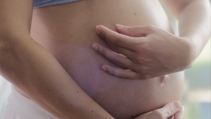 孕妇抚摸腹部孕妇抚摸怀孕的肚子幸福孕妇瑜