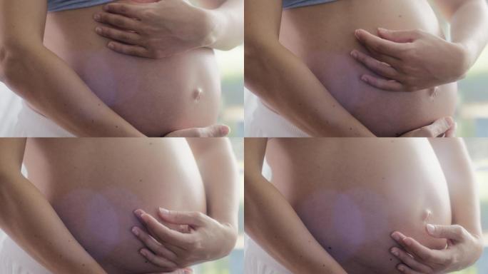 孕妇抚摸腹部孕妇抚摸怀孕的肚子幸福孕妇瑜