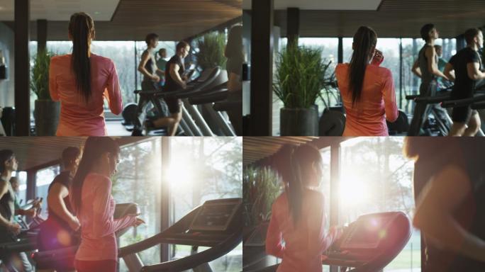 健美运动女孩在健身房的跑步机上跑步