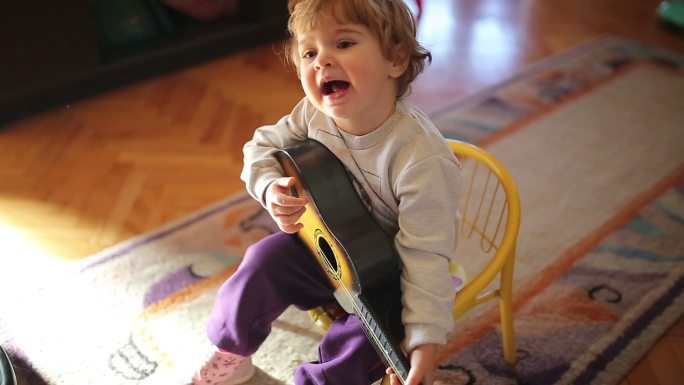 可爱的小女孩弹玩具吉他唱歌