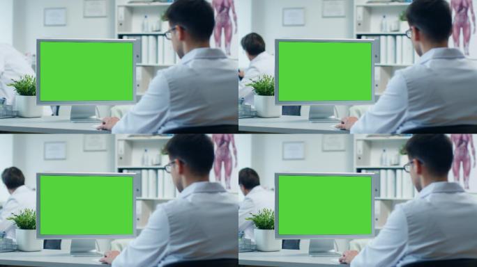 男医生在绿屏的个人电脑前工作