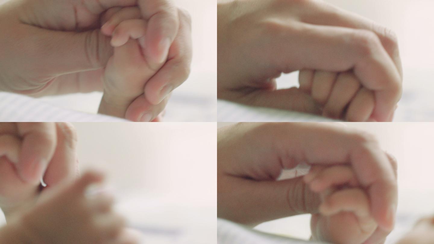 新生儿紧握着妈妈的手指