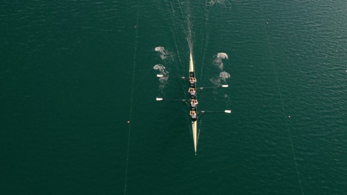 一队运动员划着船穿过湖面
