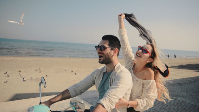 年轻游客夫妇在海滩骑车