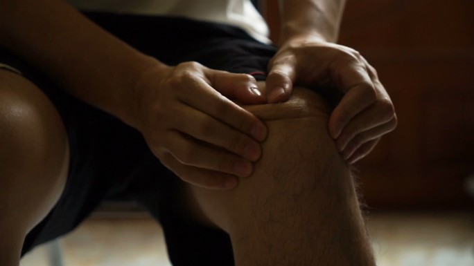 男人按摩他的膝盖人体手物理损伤健康医疗