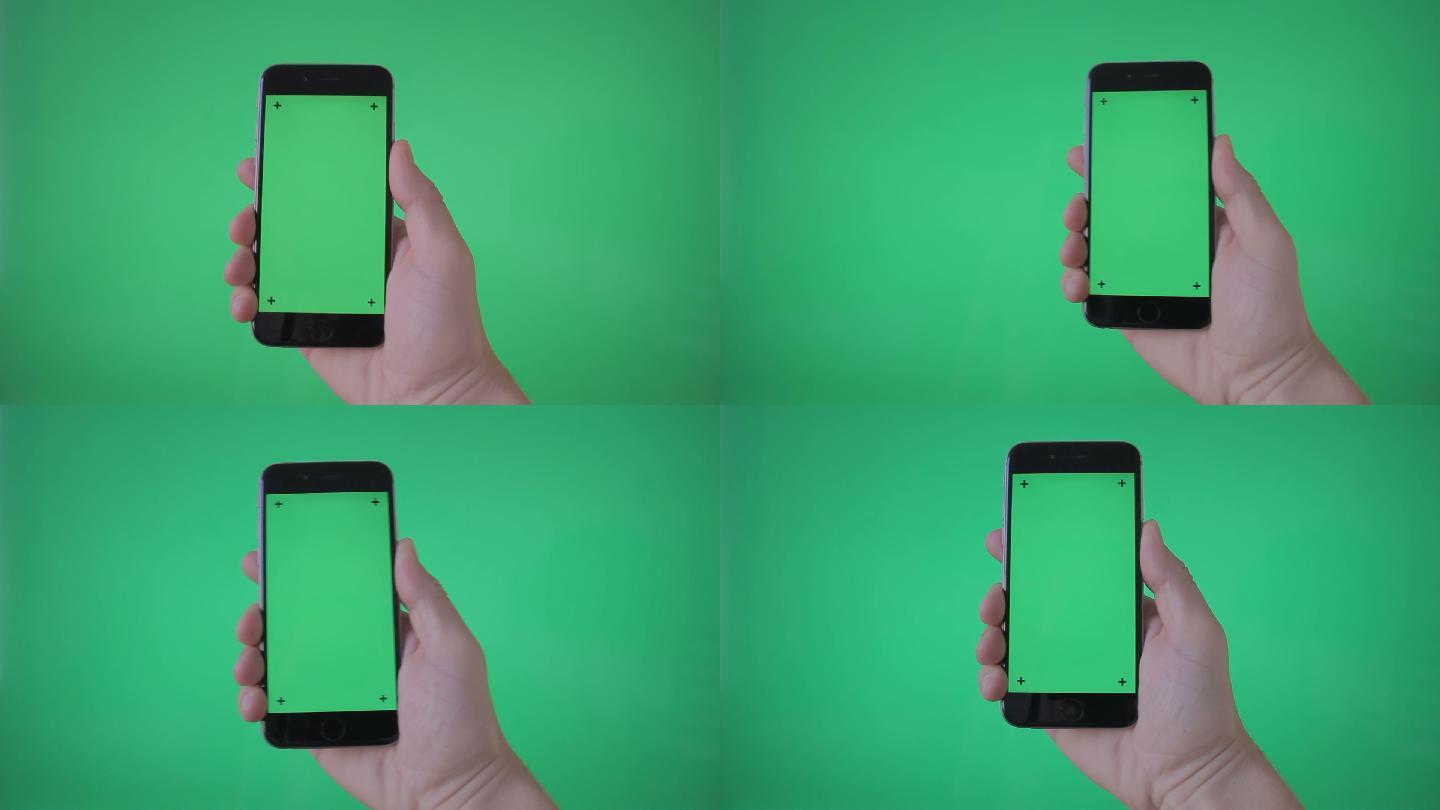 手持智能手机绿色屏幕背景