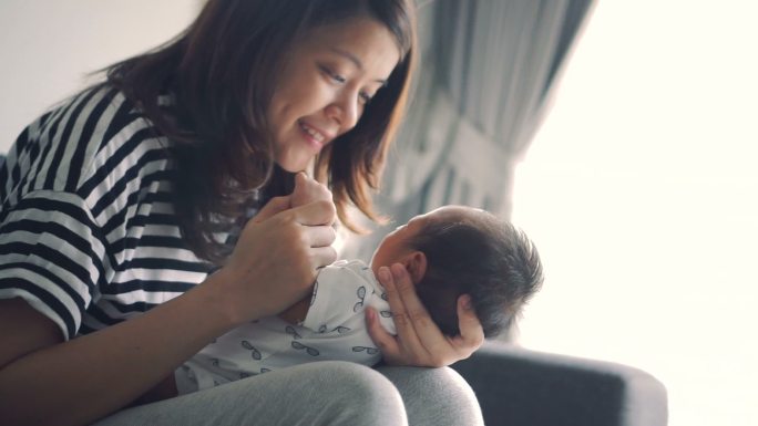 妈妈抱着她的孩子养育生育独生子母亲母爱