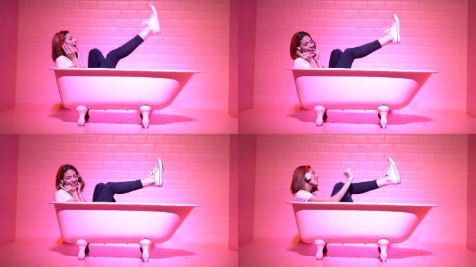 在粉红色浴缸里开心跳舞的女人
