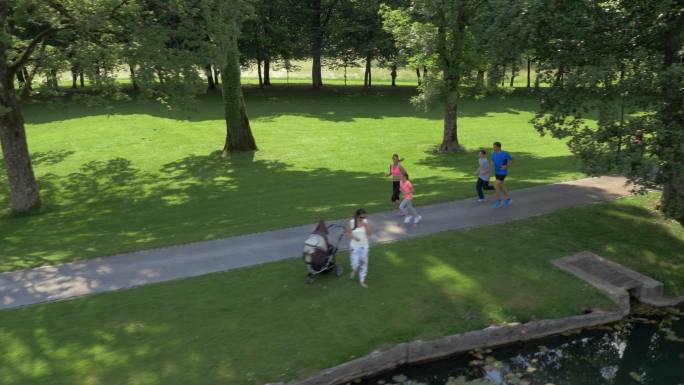 一家人在公园里沿着湖边慢跑