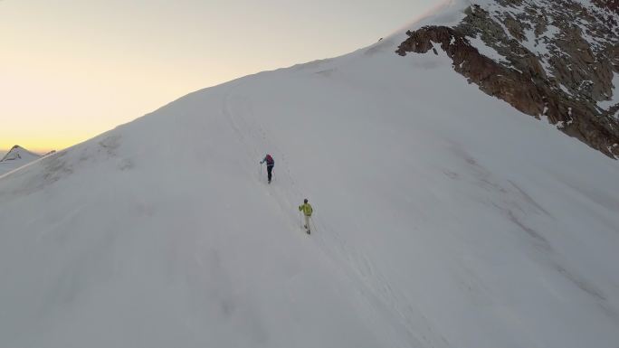 日出时登山者到达山顶的鸟瞰图