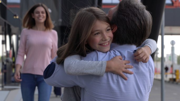激动的家人在机场拥抱接爸爸的特写镜头