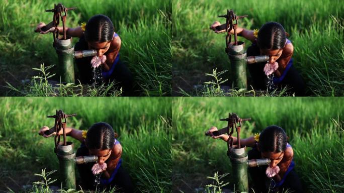小女孩在绿地边喝水