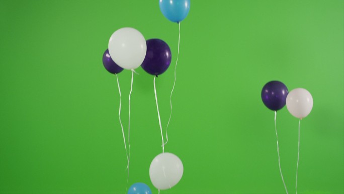 许多氦气球在绿屏上升起